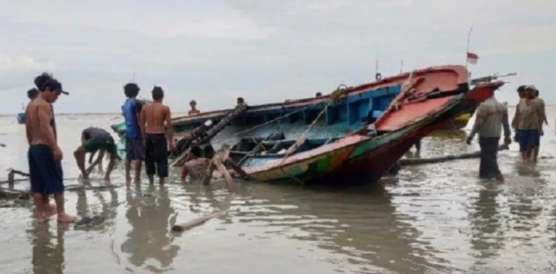 Sejumlah warga bergotong royong menarik perahu yang karam ke tepi pantai (Foto / Metro TV)