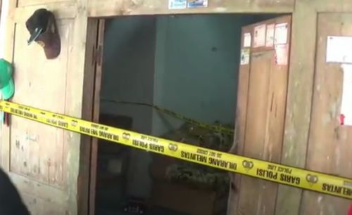 Petugas masih memasang garis polisi untuk proses penyelidikan penyebab kematian satu keluarga di Ngawi (Foto / Metro TV)