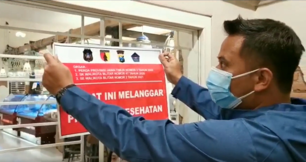 Kasubag Humas Polres Blitar Kota, Moh Rochan menyegel kafe yang melanggar prokes (Foto / Metro TV)