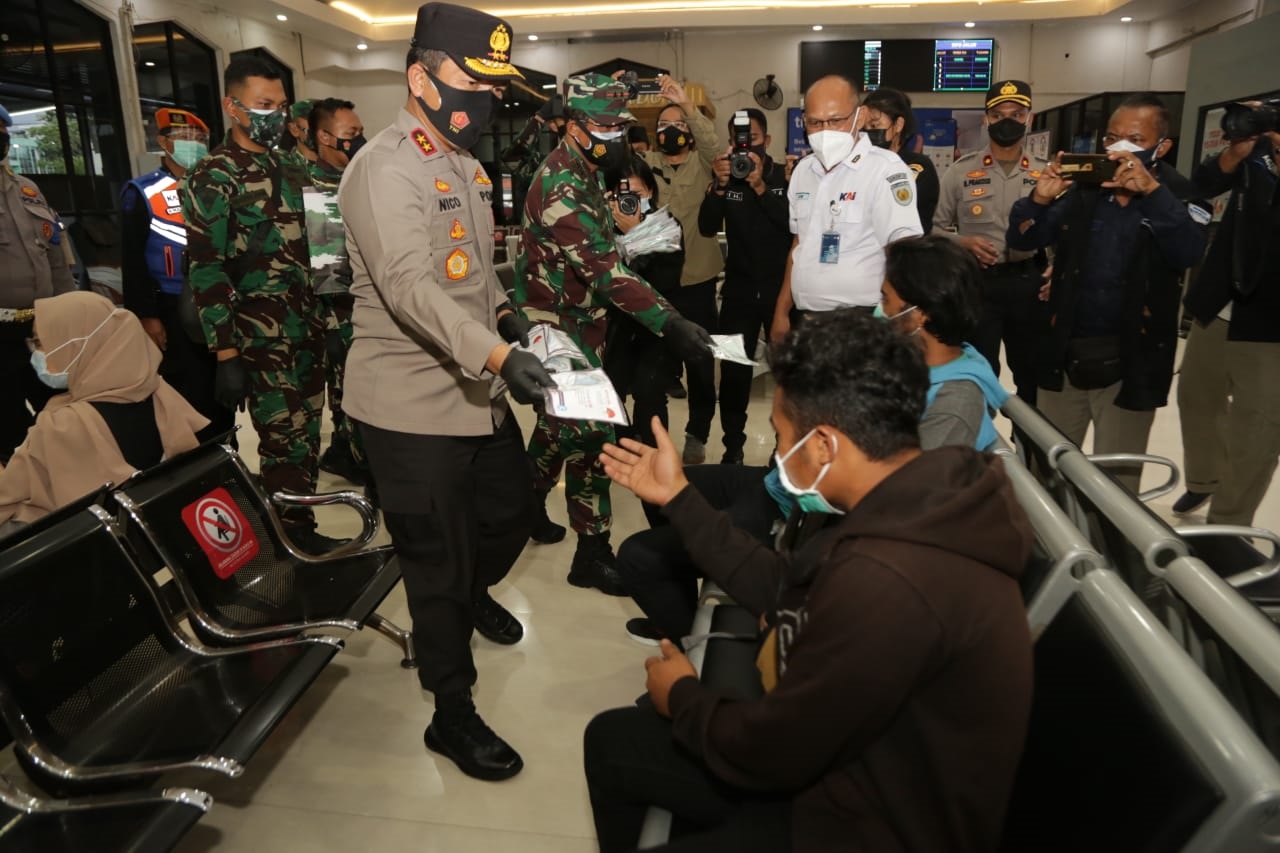 : Kapolda Jawa Timur, Irjen Pol Nico Afinta, dan Pangdam V Brawijaya, Mayjen TNI Suharyanto membagikan masker kepada penuimpang di Stasiun Pasar Turi, Surabaya (Foto / Clicks.id)