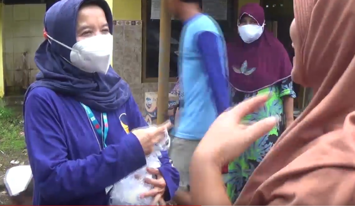 Partai Nasdem membagikan masker disela pendistribusian bantuan logistik kepada warga koban banjir di Jombang. (metrotv)