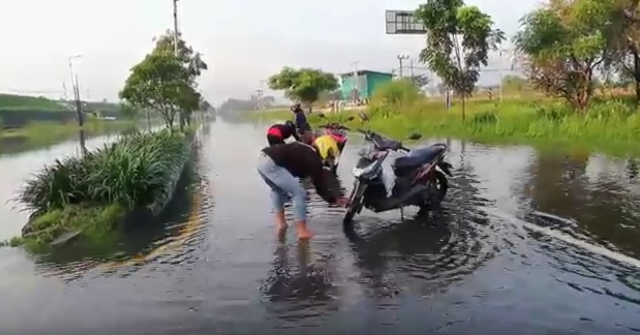 Sejumlah pengendara memanfaatkan genangan air di Jalan Raya Porong untuk mencuci motor. (metrotv)