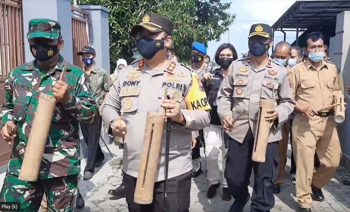 Kapolres Mojokerto, AKBP Dony Alexander memukul kentongan untuk memberikan edukasi protokol covid-19 kepada warga kampung. (metrotv) 