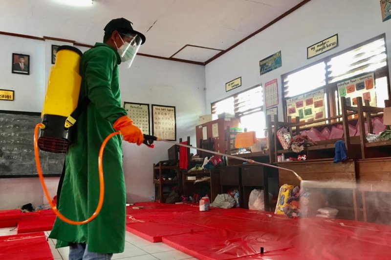 Petugan melakukan penyemprotan disinfektan di lokasi pengungsian korban longsor Nganjuk. (ft/medcom)