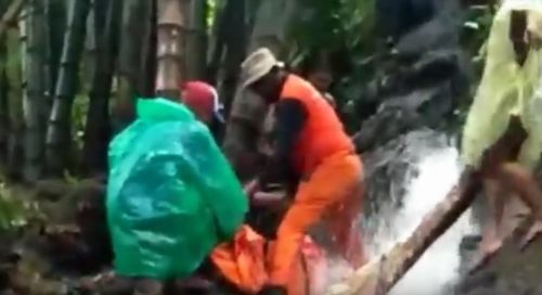 Petugas mengevakuasi jasad korban yang terseret arus sungai di Pasuruan. (metrotv)