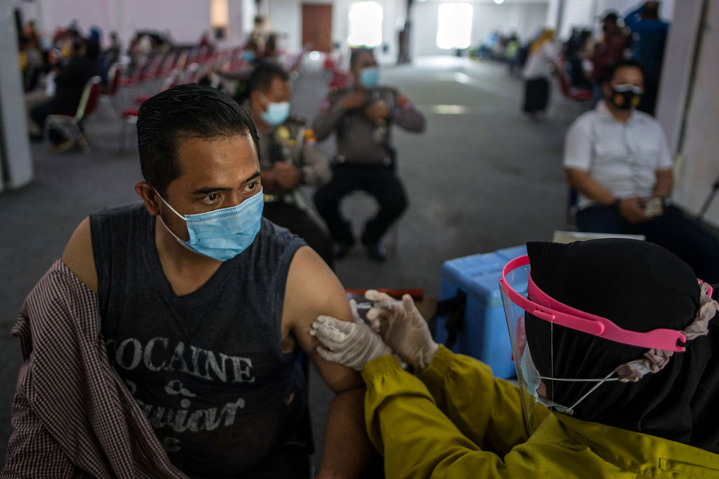 Anggota Polri disuntik vaksin covid-19 di Malporestabes Surabaya (AFP PHOTO/Juni Kriswanto)