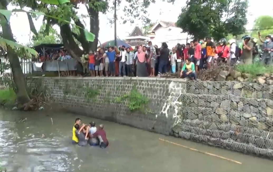 Sejumlah warga mengevakuasi bocah yang tenggelam di bendungan Sungai Desa Jururejo, Ngawi. (metrotv)