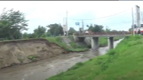 Kondisi tanggul sungai yang longsor mengancam jembatan penghubung Surabaya-Madiun. (metrotv)