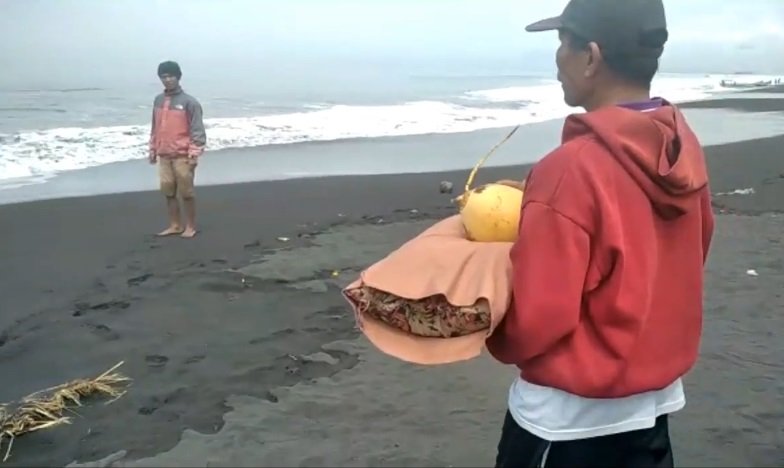 Orang tua korban menggelar ritual membuang bantal dan kelapa kuning ke tengah laut sebagai ikhtiar agar korban bisa segera ditemukan (Foto / Metro TV)