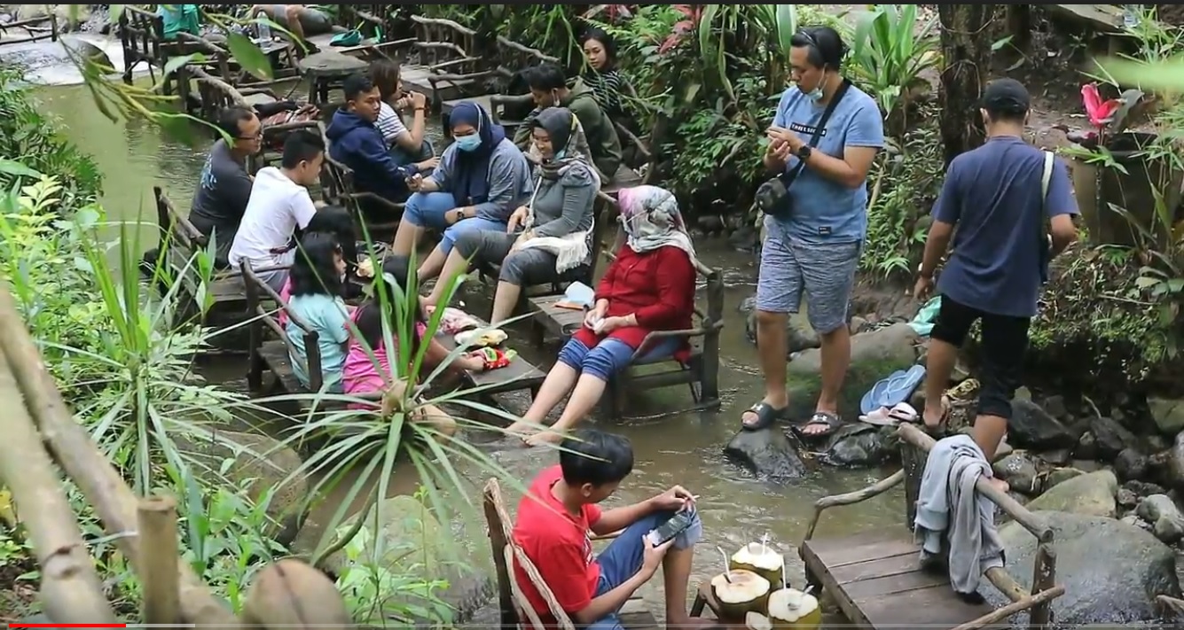 Para pengunjung menikmati sensasi ngopi di tengah aliran sungai di lokasi Coban Tarzan, Malang (Foto / Metro TV)