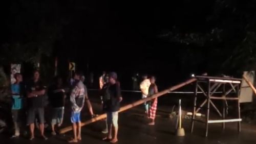 Warga menutup jembatan yang tiba-tiba ambrol saat hujan menguyur wilayah Magetan. (metrotv)