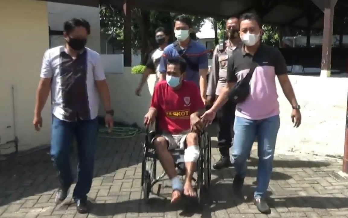 Tersangka Bunadi dikeler dengan menggunakan kursi roda setelah kedua kakinya ditembak polisi (Foto / Metro TV)