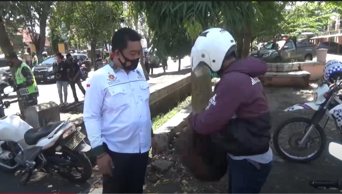 Petugas gabungan memeriksa tas ransel yang dikenakan pengendara motor yang melintas di Jalan Gus Dur, Jombang. (metrotv)