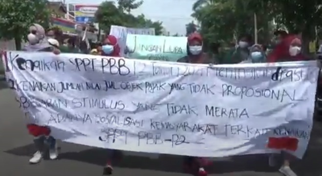 Massa mahasiswa membentangkan spanduk mengencam kenaikan pajak bumi dan bangunan di Tulungagung. (metrotv)