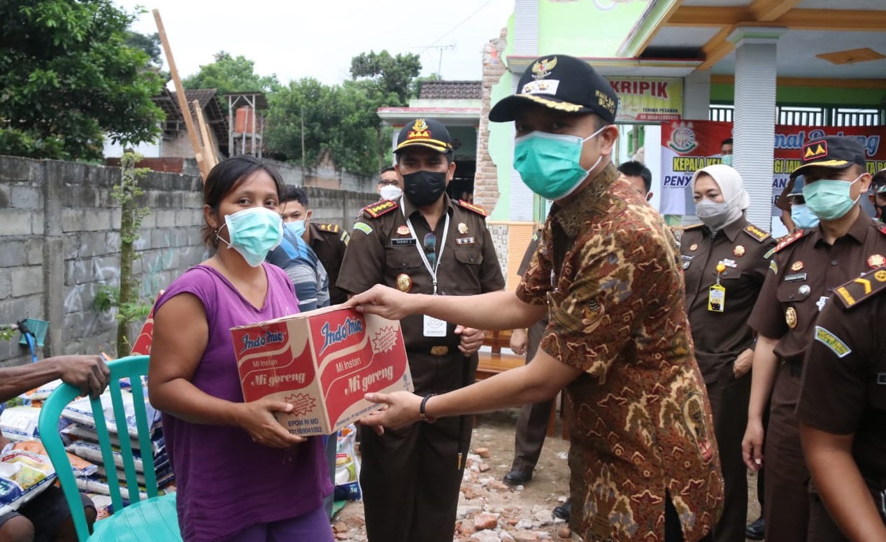 Kepala Kejati (Kajati) Jatim, M Dhofir didampingi Wakil Bupati Blitar Rahmat Santoso saat membagikan sambako untuk korban gempa (Foto / Clicks.id) 