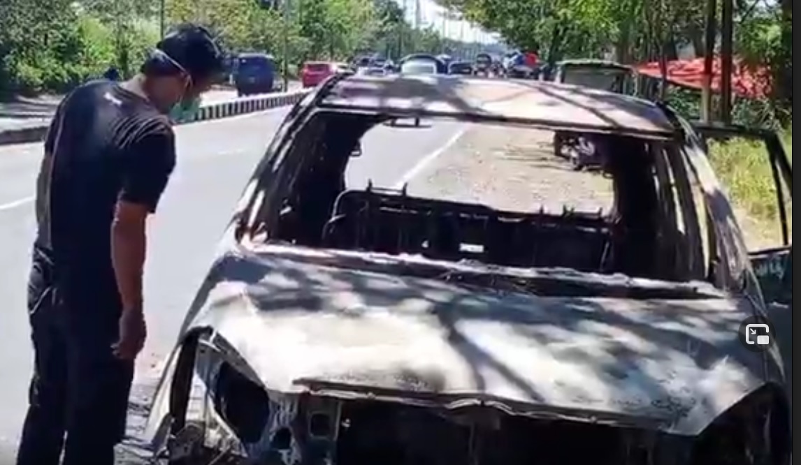 Kondisi mobil yang hangus terbakar berada di tepi Jalan Raya Porong, Sidoarjo. (metrotv)