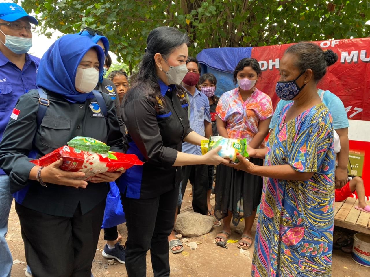 Sekretaris DPW Garnita Malahayati Partai Nasdem Jatim, Lilyana Phandeirot, menyerahkan bantuan sembako pada warga kurang mampu