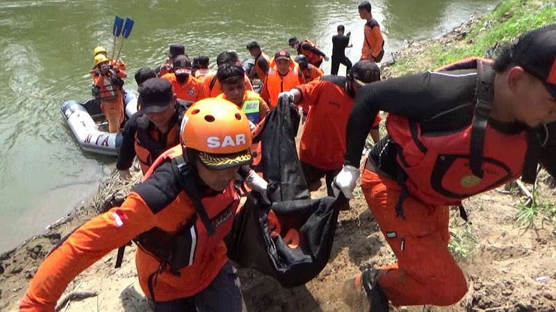 Petugas mengevakuasi jasad Riyanto yang tewas tenggalam di sungai Ngawi (Foto / Metro TV)