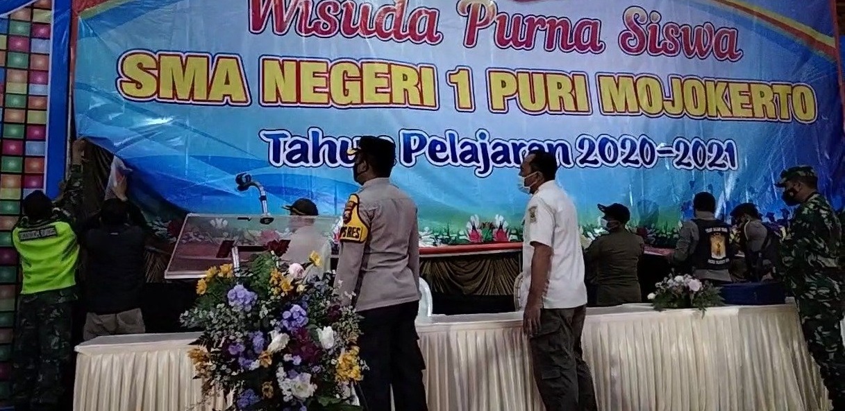 Satgas Covid-19 Mojokerto mencopot paksa banner wisuda yang dinilai melanggar aturan protokol kesehatan (Foto / Metro TV)