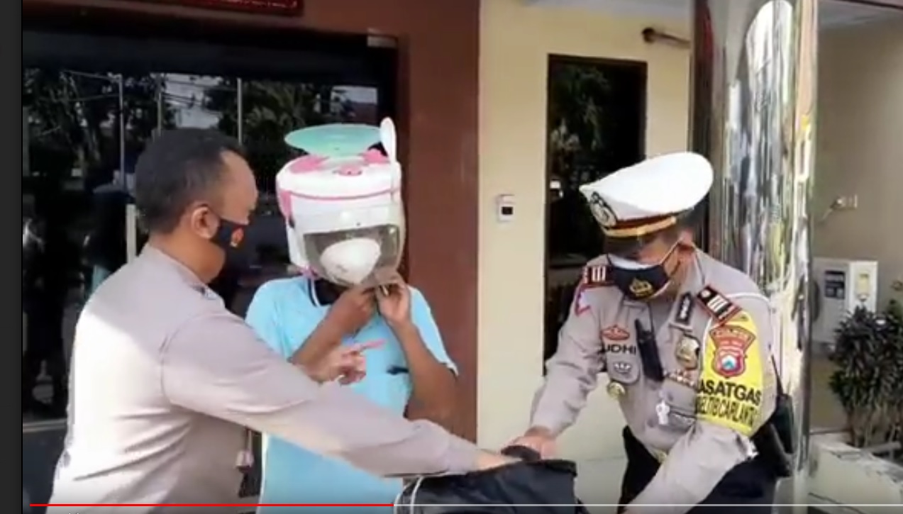 Pengendara motor berhelm magic com digiring ke Polres Pasuruan. (metrotv)