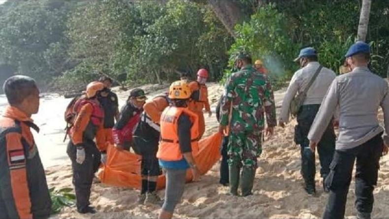 Petugas mengevakuasi jasad Nur Hakim yang tewas terjatuh hingga terseret ombak di Pantai Kondang Merak Malang (Foto / Metro TV)