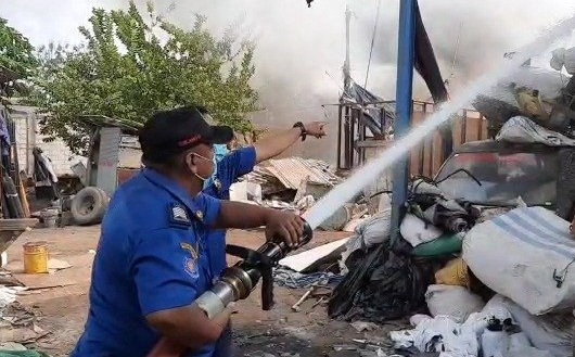 Petugas PMK tengah memadamkan api yang membakar gudang pengepul barang bekas di Mojokerto (Foto / Metro TV)