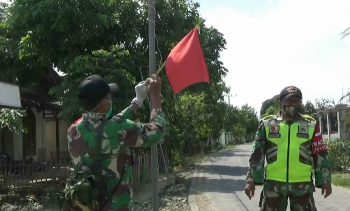 Satgas Covid-19 memasang bendera merah di rumah warga yang terpapar covid-19. (metrotv)