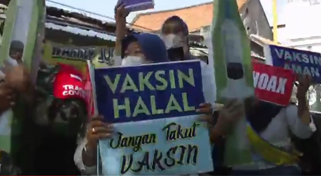 Aksi para tenaga kesehatan Gresik naik mobil bak terbuka sambil menenteng berbagai poster pentingnya vaksin. (metrotv)