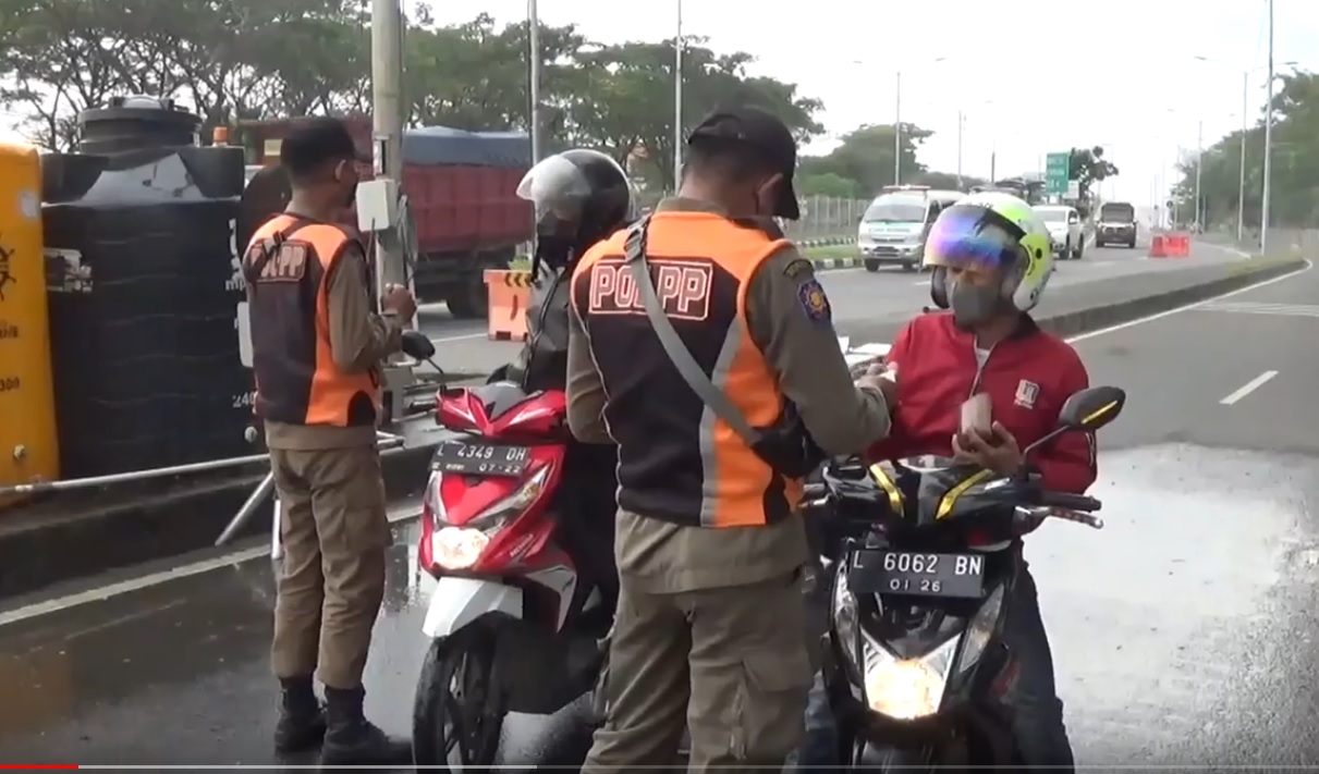 Petugas gabungan dari Pemkot Surabaya memeriksa pengendara yang keluar dari jembatan Suramadu. (metrotv)