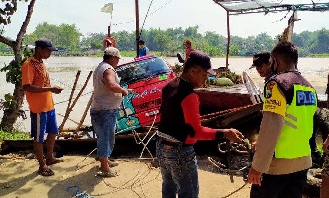 Petugas dan warga mengevakuasi truk yang nyaris tenggelam di sungai Brantas Jombang (Foto / Metro TV)