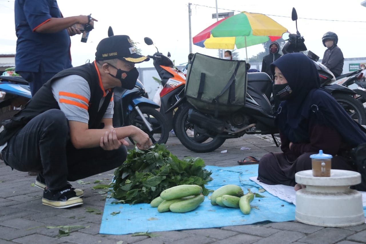 Wakil Bupati Blitar, Rahmat Santoso memborong sayur milik pedagang saat operasi yustisi. (ist)