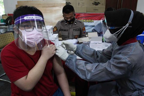 Seorang anak mendapatkan vaksinasi covid-19 di Polrestabes Surabaya, Jawa Timur, Sabtu (10/7/2021). (foto/antara)