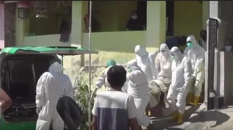 Petugas mengevakuasi jenazah pasien covid-19 yang meninggal dalam rumah. (metro)
