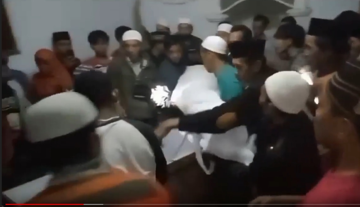 Warga mengangkat beramai-ramai jenazah pasien covid-19 dari peti mati. (metrotv)