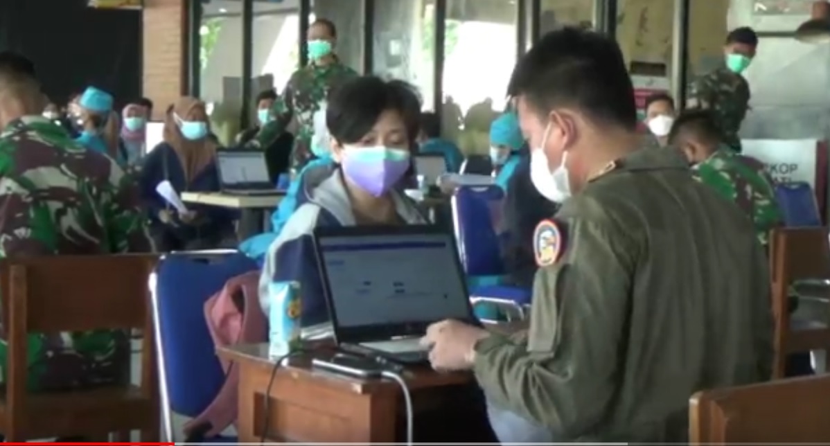 Salah satu pilot pesawat militer Puspenerbal membantu menjadi petugas entry data vaksinasi di Bandara Juanda Surabaya. (metrotv)