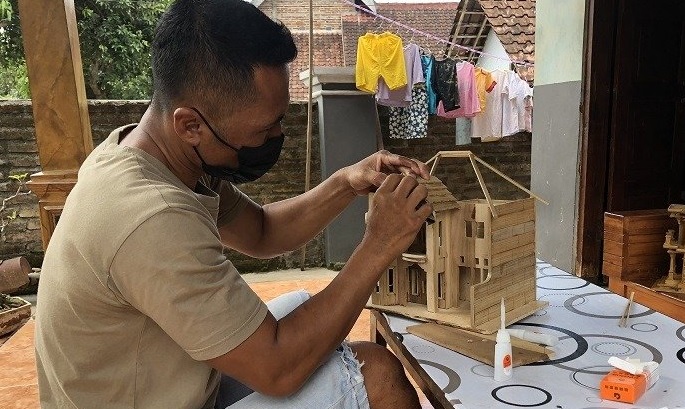 Hari tengah sibuk menyusun bambu untuk dijadikan miniatur rumah mewah (Foto / Istimewa)