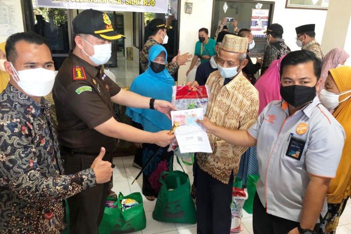 Kepala Kejari Sidoarjo Arief Zahrulyani memantau langsung pembagian bantuan beras dan BST dari Kemensos. (metrotv)