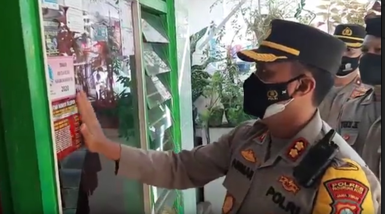 Kapolres Pasuruan Kota, AKBP Arman menempelkan stiker di rumah warga. (metrotv)