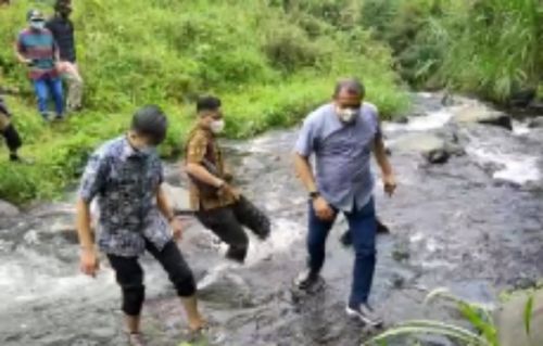 Wabup Blitar Rahmat Santoso saat menyebrangai sungai di lereng bukit. (hum)
