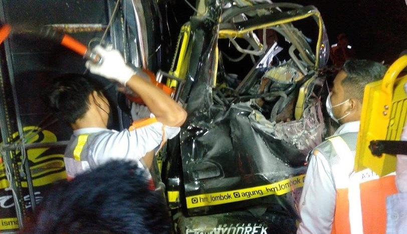 Petugas mengevakuasi dua korban tewas yang terjepit bodi truk (Foto / Metro TV)