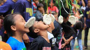 Lomba makan kerupuk saat memperingati kemerdekaan RI 17 Agutus ( Foto / Istimewa)