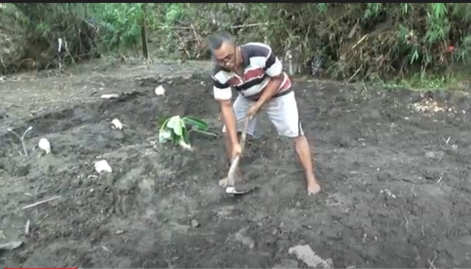 Warga memperbaiki  makam yang rusak akibar diterjang banjir bandang. (metrotv)