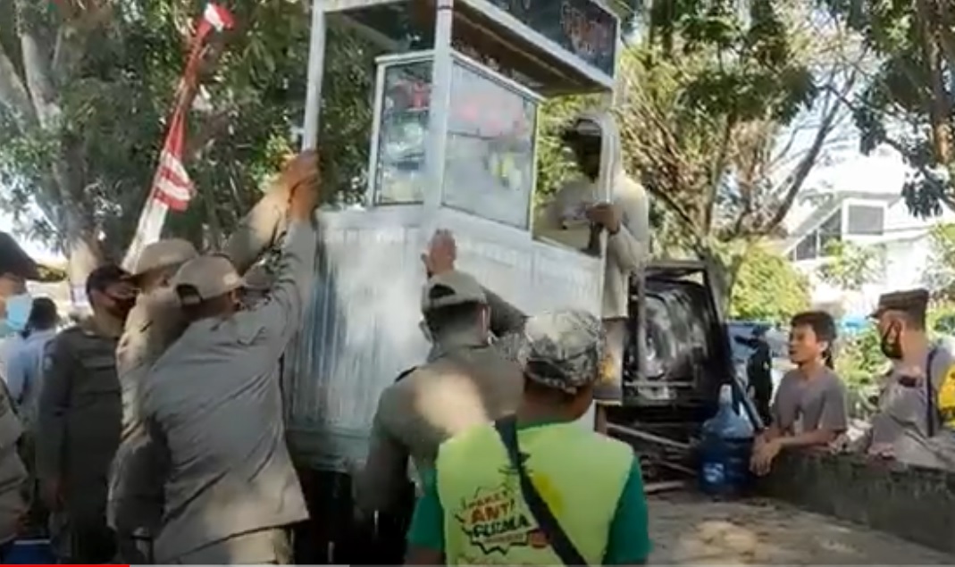 Petugas gabungan mengangkut gerobak milik pedagang yang nekat berjualan di bahu jalan. (metrotv)