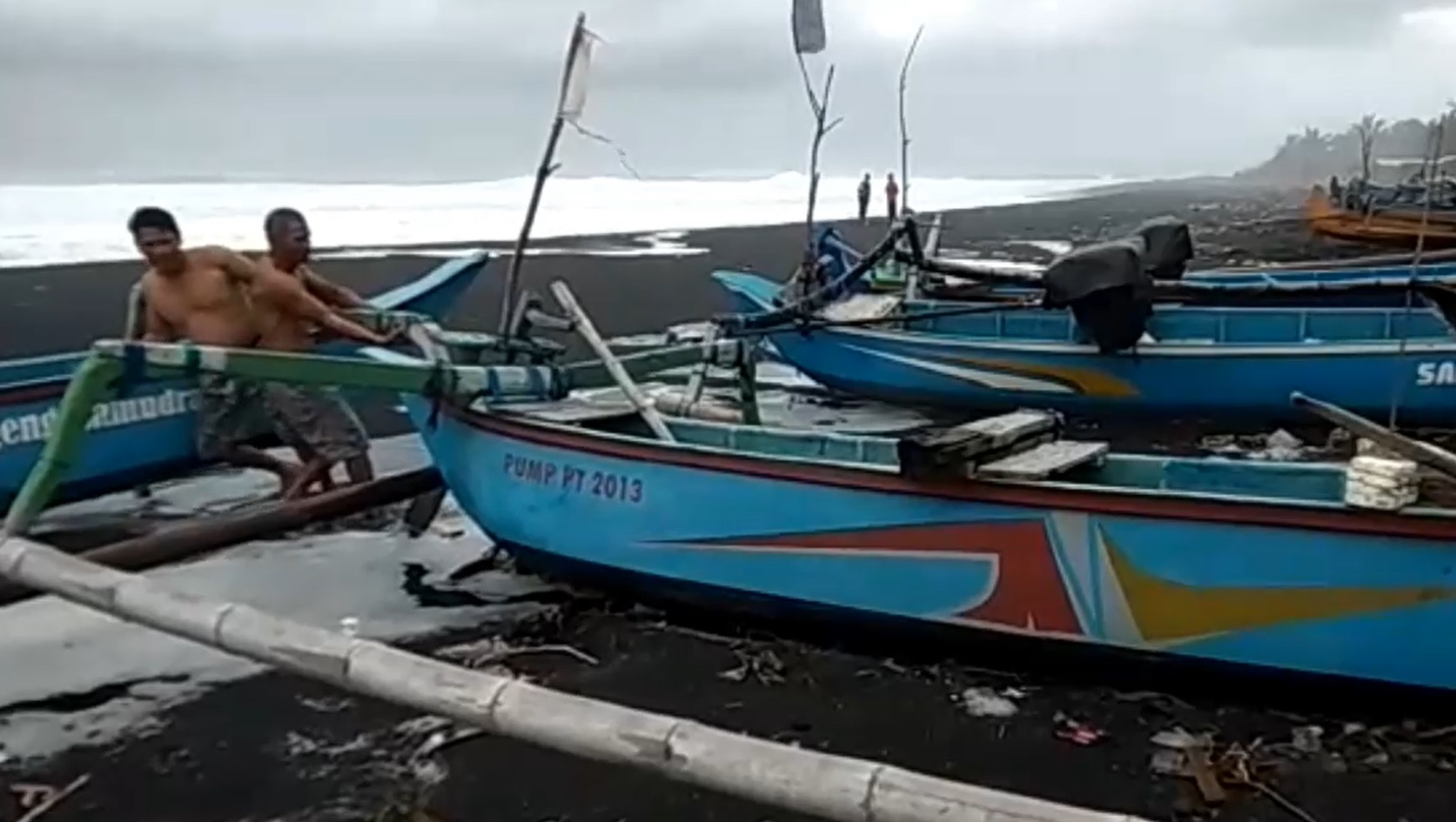 Sejumlah nelayan mengamankan perahunya dari terjangan gelombang di bibir  Pantai Watu Pecak, Desa Selok Awar-awar, Lumajang. (metrotv)