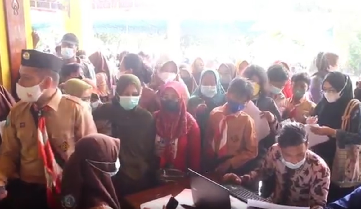 Sejumlah orang tua siswa ikut antre berdesakan dalam kegiatan vaksinasi di Pendopo Pratanu Bangkalan, Madura. (metrotv)   