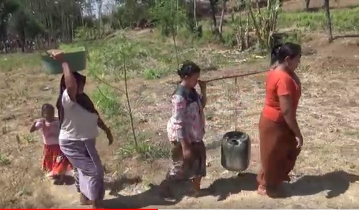 Warga di Dusun Polai, Desa Jatisari, Kecamatan Arjasa  berjalan kaki sambil memikul air bersih yang dibelinya. (metrotv)