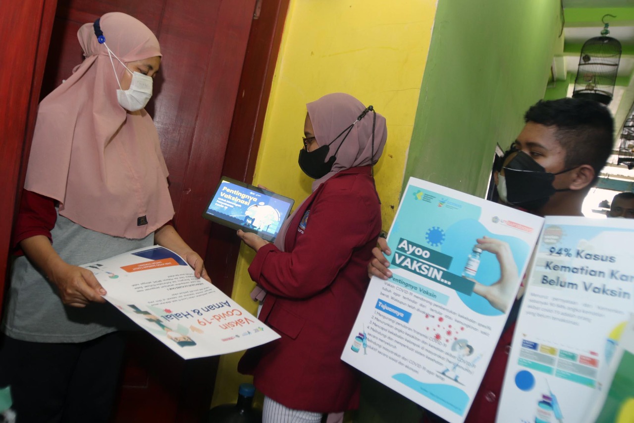 Mahasiswa FIK Universitas Muhammadiyah Surabaya, memberikan edukasi kepada warga sekitar kampus, terkait vaksinasi covid-19 (Foto / Metro TV)