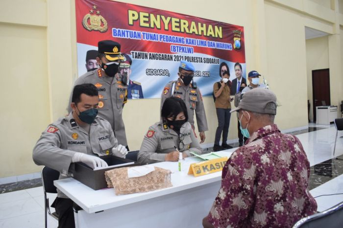 Salah satu PKL menerima bantuan uang tunai di kantor Polresta Sidoarjo, Jawa Timur. (metrotv)