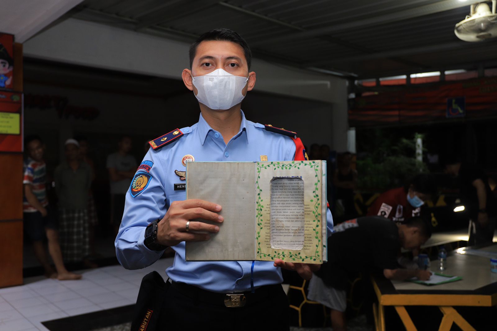 Petugas menunjukkan barang bukti buku yang sudah dimodifikasi untuk menyelundupkan handphone (Foto / Metro TV)