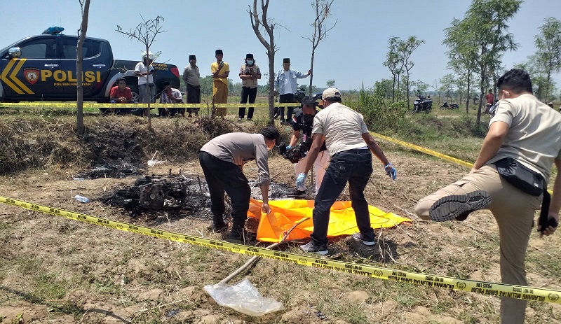 Polisi mengevakusi mayat terduga pelaku pencurian yang tewas dibakar warga (Foto / Metro TV)